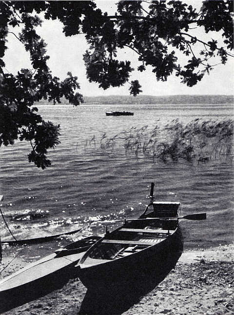 Blick auf den See mit einem vertäuten Kahn im Vordergrund