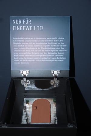 "Mitmachdeckel" in der Ausstellung. Sie sind mit einem Fragezeichen bezeichnet, Besucher können Sie öffnen und eine konkrete Erfahrung mit nach Hause nehmen. Was verbirgt sich hier hinter diesem Türchen?