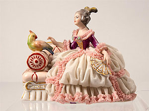Ausstellungsstück: Dame mit Papagei auf einem Sofa sitzend.