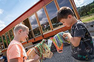 Zwei Kinder mit  selbst gebastelten Steckenpferden